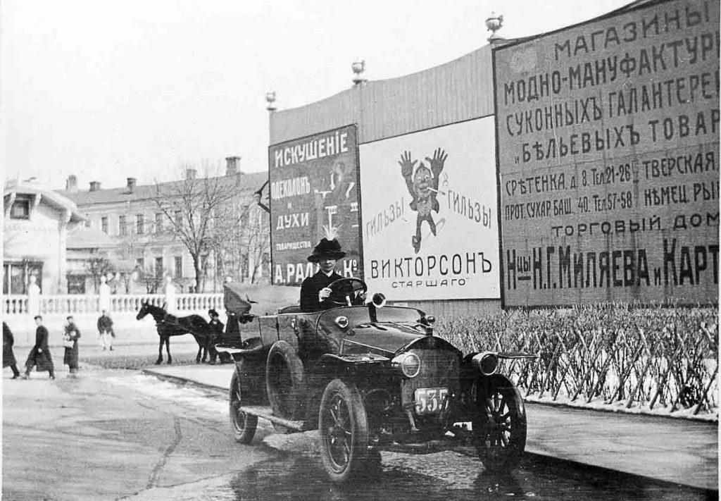 An advertisement for Ralle cologne and perfume at the entrance to the Hermitage Theatre and Gardens in Moscow. A woman drives a Berliet. Early 20th century.