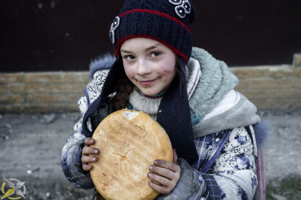 Даша с буханкой хлеба. Мариуполь. 2022 год