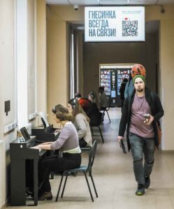 Students practicing on silent pianos in the academy corridors