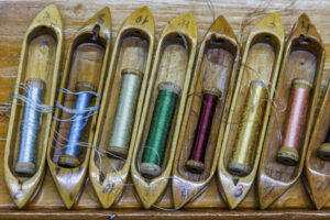 Челноки-лодочки от ткацких станков уже не служат по прямому назначению, но по-прежнему несут в себе яркие шелковые нити