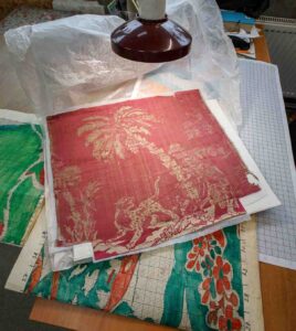 Художники кропотливо переносят узор с фрагмента подлинной старинной ткани на канвовую бумагу