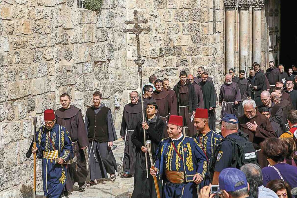 A procession of Franciscan monks. The square before the Church of the Holy Sepulchre in Jerusalem.
